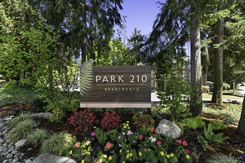 Park 201 Welcome Sign with Expertly Manicured Flowers and Trees at Park 210 Apartment Homes, Edmonds, Washington